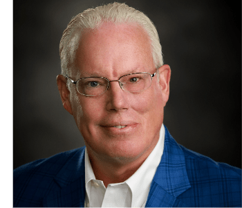 A man wearing glasses and a blue suit.