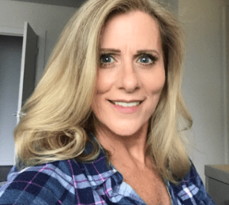 A headshot of a woman wearing a checked shirt